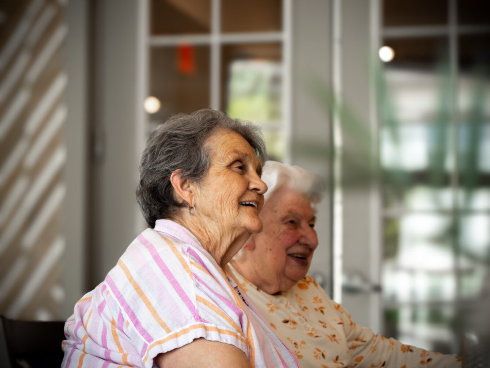 Two senior women smiling and chatting at The Glades at ChampionsGate community