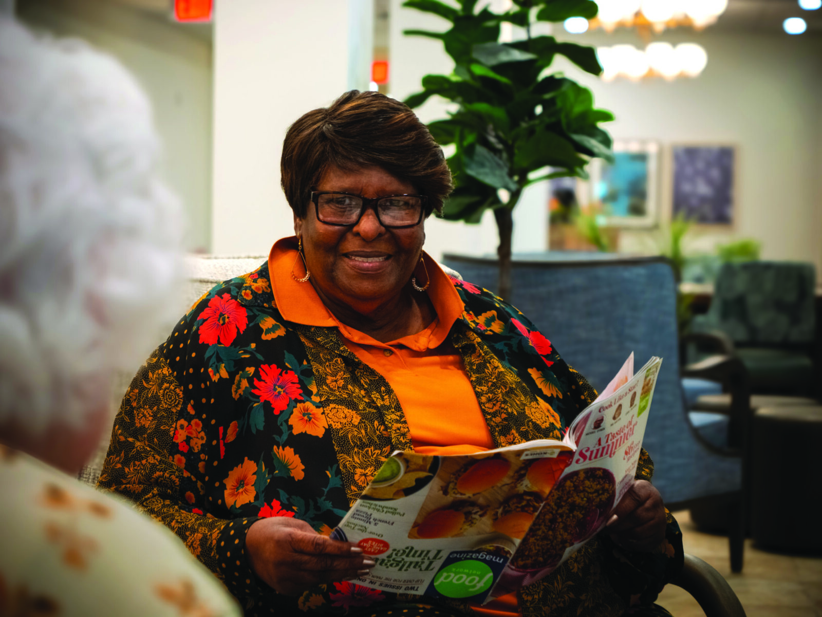 Senior woman reading a magazine and smiling at The Glades at ChampionsGate community